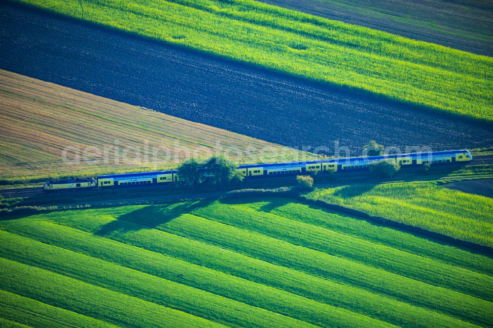 Neuhaus (Oste) from above - Regional train and passenger train Start in motion on the tracks of the route in Neuhaus (Oste) in the state Lower Saxony, Germany