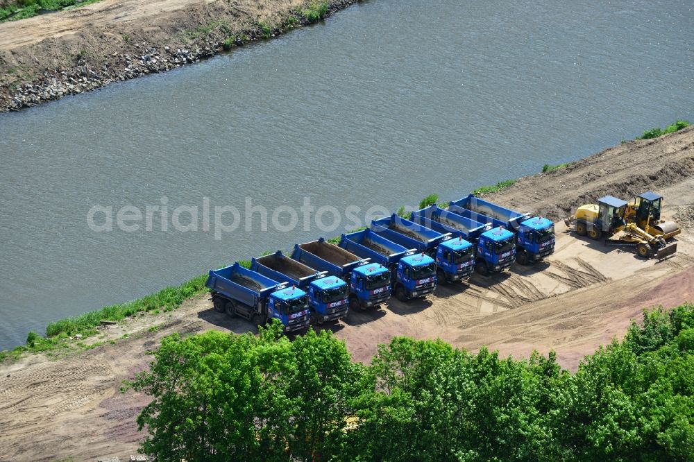 Aerial image Ihleburg - Series of Mercedes trucks of REINERT Logistic GmbH & Co. KG at a construction site on the banks of the Elbe-Havel Canal at Ihleburg in Saxony-Anhalt