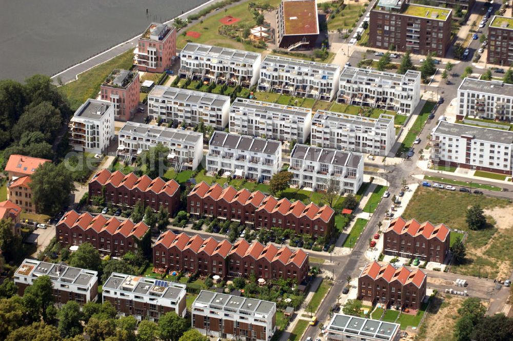 Aerial image Berlin - Blick auf einen Teil der Terrassen- und Reihnhäuser am Rummelsburger Ufer, die Bestandteil des New Rummelsburg sind. Alle Häuser sind giebelständige Reihenhäuser mit Dachterrassen, die im Baugruppenverfahren errichtet wurden und auch einen gemeinschaftlichen Hain mit einschließen. Diese Backsteingebäude werden dabei von einer Reihe schwarz-weißer Atelierhäuser umschlossen. Es ist ein Projekt der KELLER & PUDRITZ Projektentwicklungs GmbH. Kontakt: