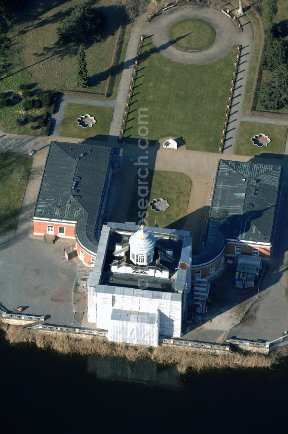 Potsdam from above - Im Potsdamer Neuen Garten, dicht am Ufer des Heiligen Sees, ließ Friedrich Wilhelm II. in den Jahren 1787–1792 das Marmorpalais errichten. Die Architekten Carl von Gontard und ab 1789 der Erbauer des Brandenburger Tors in Berlin, Carl Gotthard Langhans, schufen ein Schlossgebäude im Stil des Frühklassizismus.1961 wurde in dem Gebäude das Deutsche Armeemuseum der DDR eingerichtet. Im Innern wurde historisches Kriegsgerät, Uniformen und Zeitdokumente ausgestellt, im Außenbereich Kanonen, ein Panzer T-34, ein Schnellboot, ein MiG-Jagdflugzeug und eine Rakete. Die Waffen wurden 1989 entfernt. Die Nationale Volksarmee der DDR plante seit 1984 eine grundlegende Instandsetzung, da das Gebäude immer mehr verfiel. Zur Ausführung kam dieser Plan 1988 und wurde im Spätherbst 1990 nach der Rückgabe an die Schlösserverwaltung von dieser fortgeführt. Seit dem 14. April 2006 sind alle vierzig Innenräume restauriert und für die Öffentlichkeit zugänglich. Die Außenfassade soll 2008 fertiggestellt sein. Neuer Garten,14469 Potsdam,Telefon:+49-(0)331-9694 246