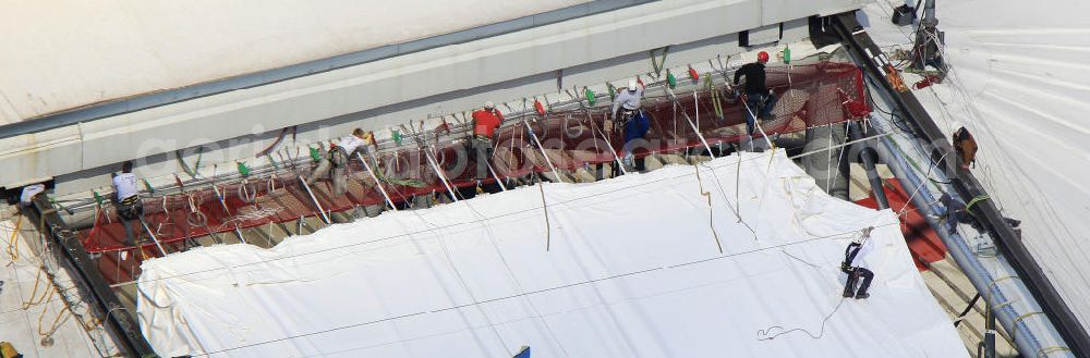 GELSENKIRCHEN from the bird's eye view: Einsatzkräfte montieren neue Membrane- Planenflächen auf dem Dach der Schalke- Arena. Im letzen Jahr wurde die Dachkonstruktion der Arena in Gelsenkirchenan sechs Stellen und auf einer Fläche von etwa 6000 Quadratmetern beschädigt. Force install new membrane-plan areas on the roof of the Schalke Arena. Last year, the roof structure at six points and an area of 6,000 square meters was damaged.