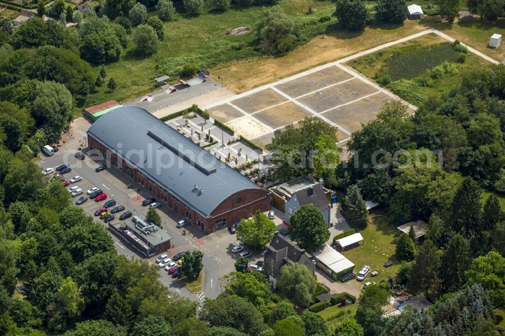 Aerial image Schwerte - Restaurant and event location Rohrmeisterei in the South of Schwerte in the state of North Rhine-Westphalia. The compound includes the historic main building with the semi-circular roof and a large open-air area. The compound is surrounded by forest and meadows