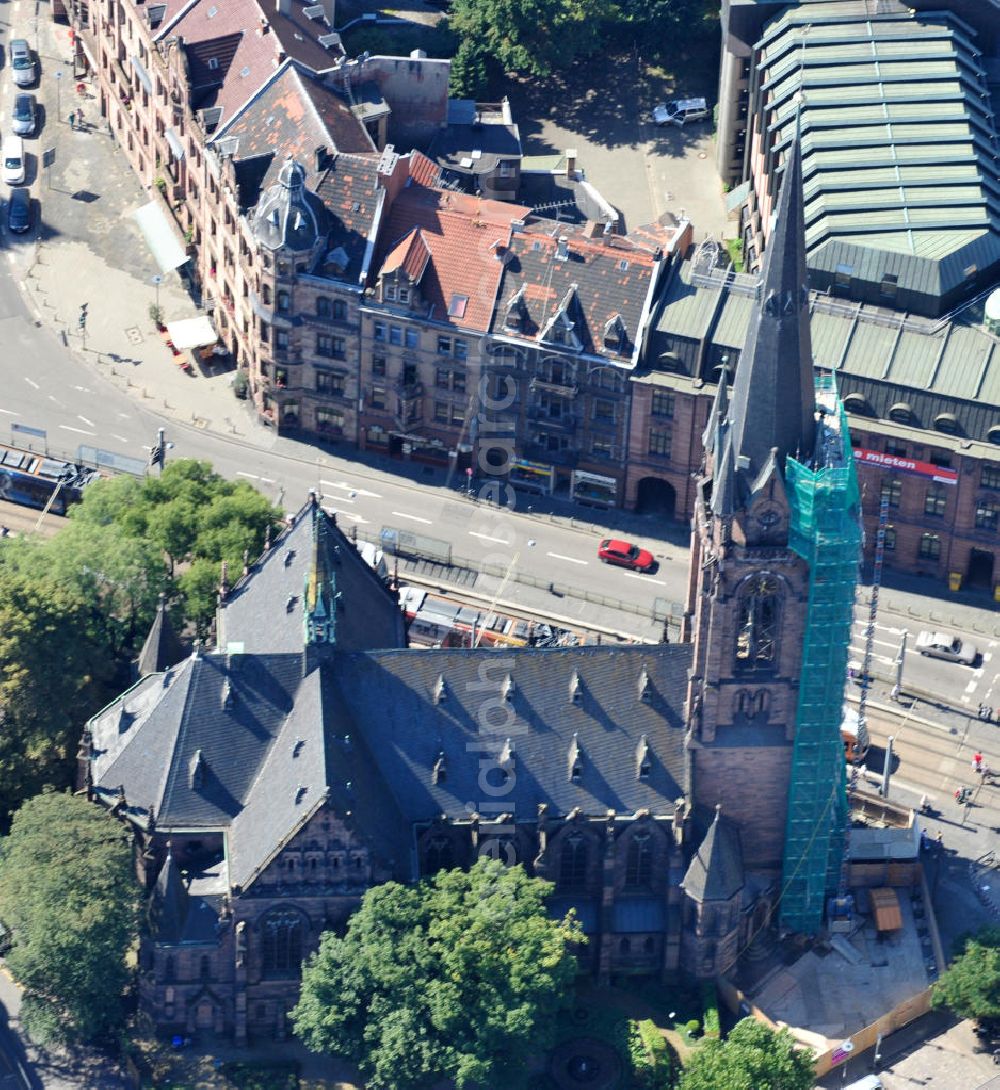 Saarbrücken from the bird's eye view: Restaurierungsarbeiten am Turm der evangelischen Johanneskirche in Saarbrücken im Saarland. Die neugotische Kirche wurde um 1895 vom Architekten Heinrich Güth erbaut. Sie steht im Saarbrückener Stadtteil St. Johann, gegenüber dem Rathausplatz. Renovation works on evangelical church Johanneskirche in city Saarbrücken in Saarland. The neo-Gothic church was built around 1895 by architect Heinrich Güth. It is located in district St. Johann, in opposition to the townhall square.