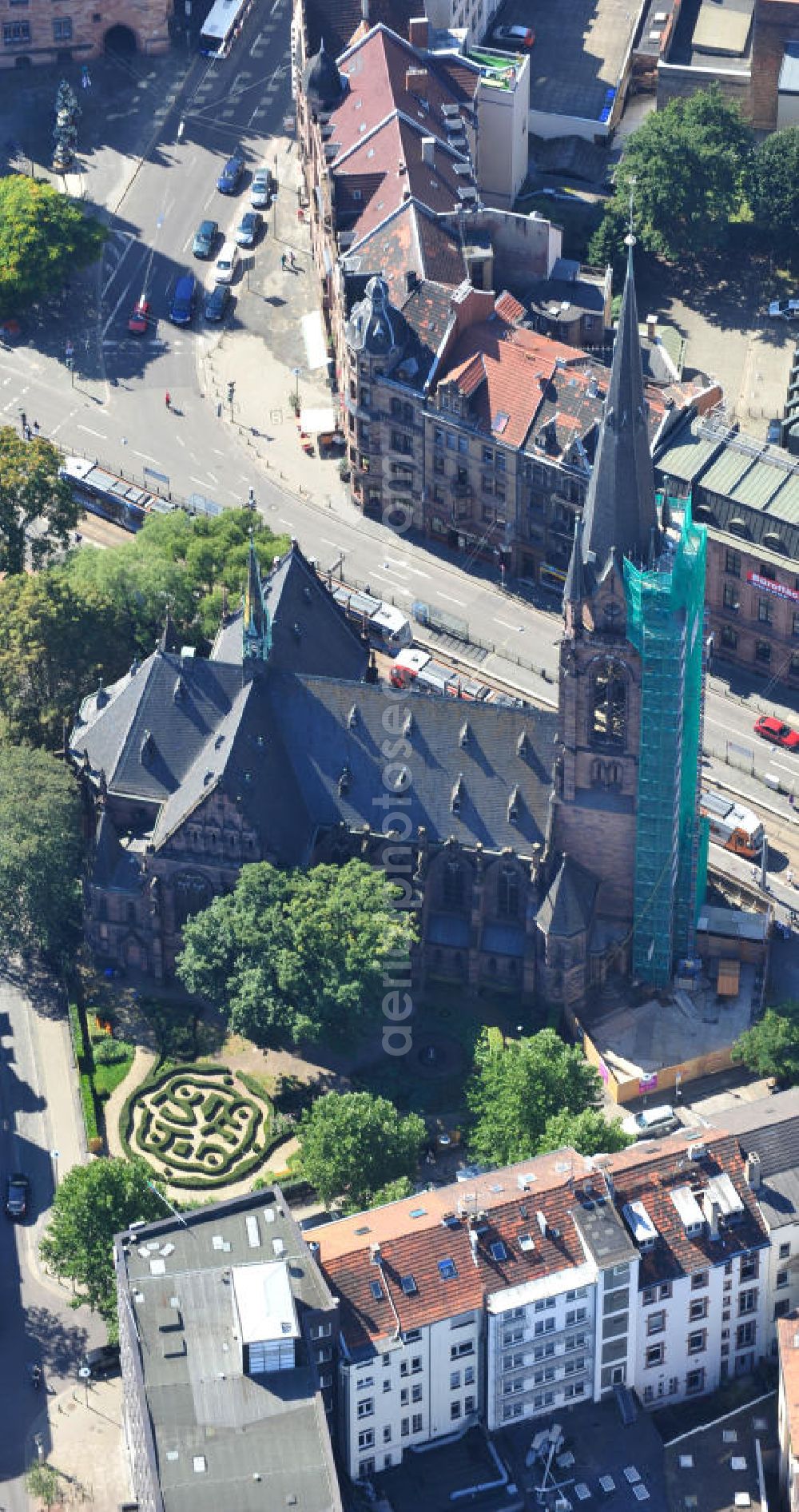 Aerial photograph Saarbrücken - Restaurierungsarbeiten am Turm der evangelischen Johanneskirche in Saarbrücken im Saarland. Die neugotische Kirche wurde um 1895 vom Architekten Heinrich Güth erbaut. Sie steht im Saarbrückener Stadtteil St. Johann, gegenüber dem Rathausplatz. Renovation works on evangelical church Johanneskirche in city Saarbrücken in Saarland. The neo-Gothic church was built around 1895 by architect Heinrich Güth. It is located in district St. Johann, in opposition to the townhall square.