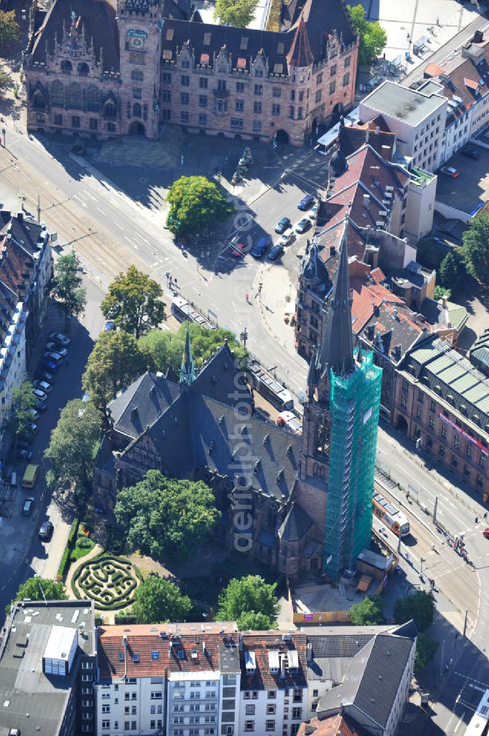 Saarbrücken from the bird's eye view: Restaurierungsarbeiten am Turm der evangelischen Johanneskirche in Saarbrücken im Saarland. Die neugotische Kirche wurde um 1895 vom Architekten Heinrich Güth erbaut. Sie steht im Saarbrückener Stadtteil St. Johann, gegenüber dem Rathausplatz. Renovation works on evangelical church Johanneskirche in city Saarbrücken in Saarland. The neo-Gothic church was built around 1895 by architect Heinrich Güth. It is located in district St. Johann, in opposition to the townhall square.