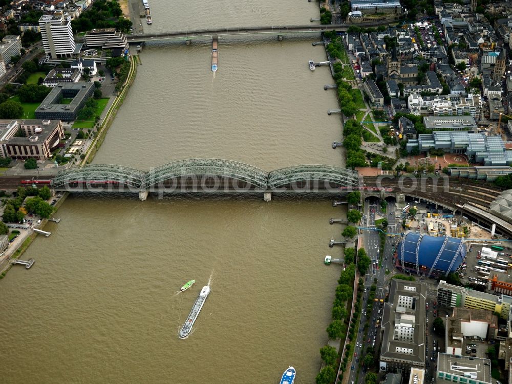 Aerial image Köln - Rhine and bridges in Cologne in the state of North Rhine-Westphalia. Cityscape of Cologne. Its historic city centre is split by the river which is spanned by the railway bridge Hohenzollernbruecke and the Deutzer Bruecke. The elaborate blue building is the Musical Dome, the interim location of the Cologne Opera