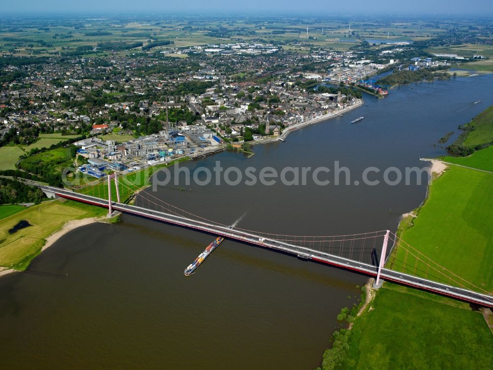 Emmerich am Rhein from the bird's eye view: The Rhine bridge and container ships on the river Rhine in the city of Emmerich on Rhine in the state of North Rhine-Westphalia. The river marks the border to the Netherlands. Cargo shipping is especially important in the area, the metropolitan area also includes the Rhine port. The bridge is Germany's longest suspension bridge