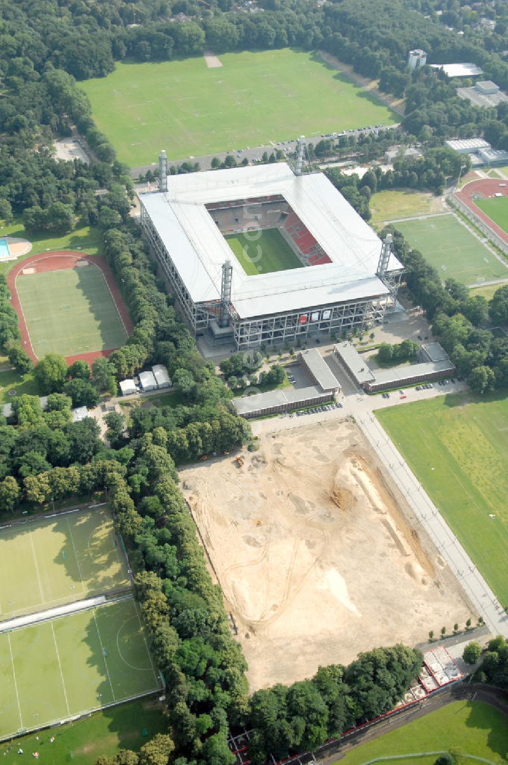 KÖLN from the bird's eye view: Blick auf das Das Rheinenergiestadion (Eigenschreibweise RheinEnergieStadion) ist eine Konzert- und Wettkampfstätte in Köln-Müngersdorf. Sein Vorläufer war das 1923 an gleicher Stelle erbaute Müngersdorfer Stadion, welches 1975 neu errichtet wurde. Durch einen Sponsorenvertrag trägt das Stadion derzeit den Namen des Kölner Energieversorgers RheinEnergie.Das knapp 51.000 Zuschauer fassende Stadion war im Jahr 2006 einer der zwölf Austragungsorte der Fußball-Weltmeisterschaft in Deutschland. Während des Turniers wurden fünf Spiele im „FIFA WM-Stadion Köln“ ausgetragen.