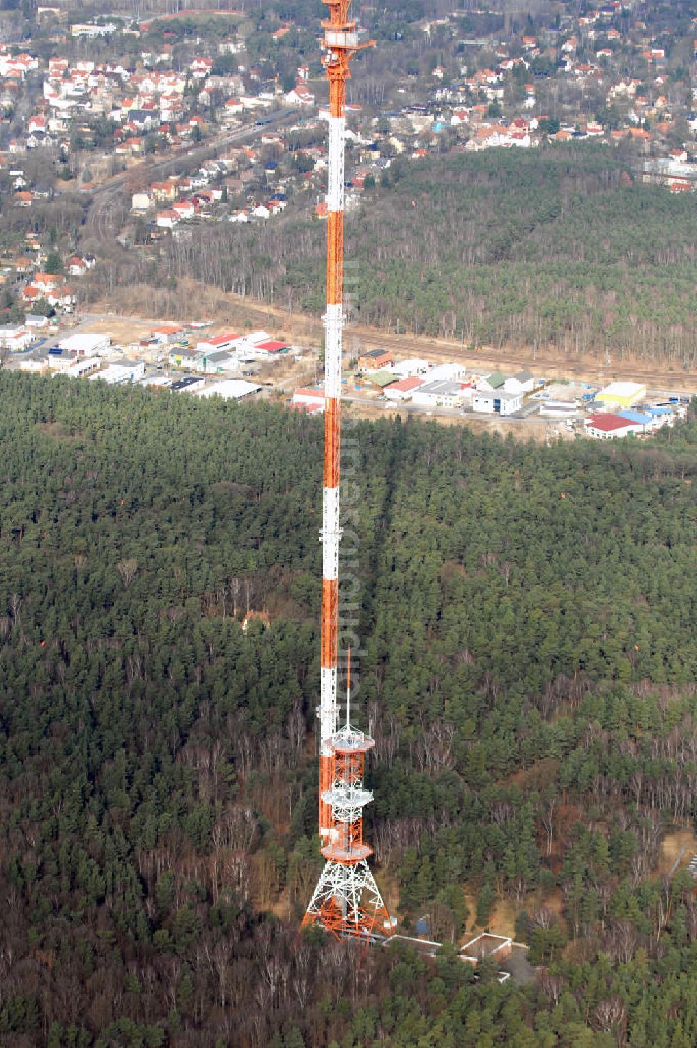 Aerial photograph Berlin-Frohnau - Blick auf die Richtfunkanlage Berlin-Frohnau. Die Richtfunkanlage Berlin-Frohnau befindet sich im Norden Berlins im Ortsteil Frohnau. Betreiber und Eigentümer der Richtfunkanlage ist die Deutsche Funkturm (DFMG), ein Tochterunternehmen der Deutschen Telekom mit Sitz in Münster. In Berlin-Frohnau steht das zweithöchste Bauwerk Berlins und eines der höchsten Bauwerke Deutschlands: Der von 1977 bis 1979 für 11,5 Mio. DM errichtete Richtfunkmast ist 358,58 m hoch und ermöglichte bis zur deutschen Wiedervereinigung eine Richtfunkverbindung mit der alten Bundesrepublik Deutschland. Der Sendemast verfügt nahe seiner Spitze über einen 4 m mal 5 m großen Betriebsraum für die Richtfunkgeräte. Er stellt den am höchsten über dem Erdboden liegenden geschlossenen Raum aller Bauwerke im EU-Gebiet dar. Kontakt: DFMG Deutsche Funkturm GmbH, 48008 Münster, Tel.: 0228181–4949,