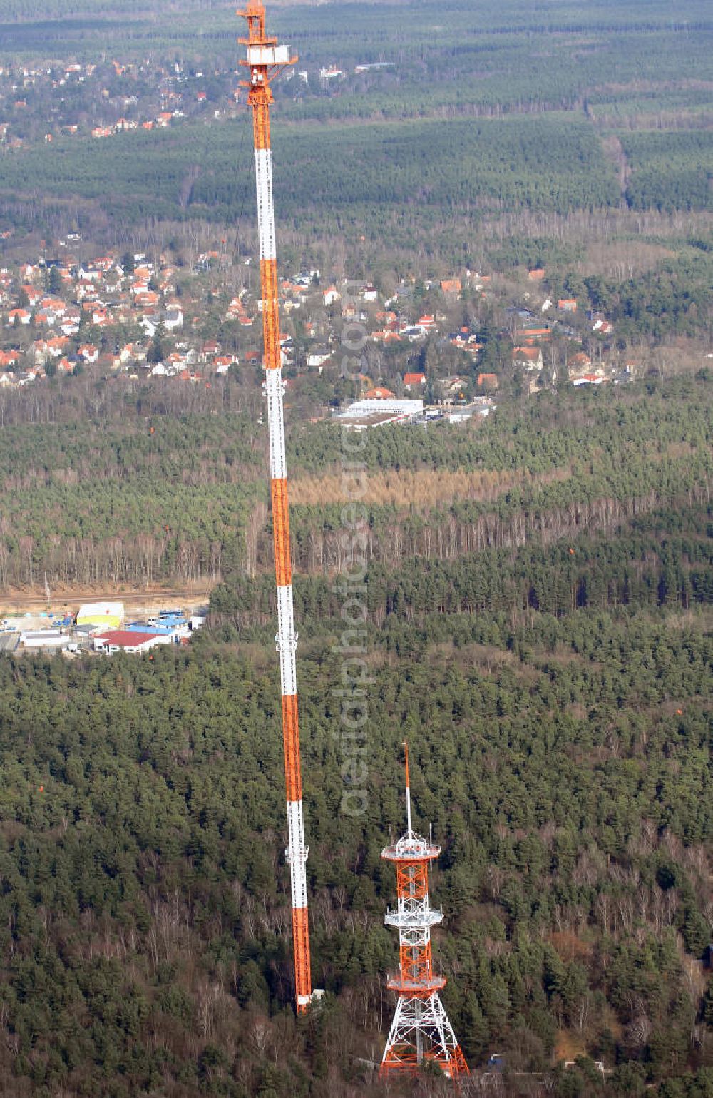 Aerial image Berlin-Frohnau - Blick auf die Richtfunkanlage Berlin-Frohnau. Die Richtfunkanlage Berlin-Frohnau befindet sich im Norden Berlins im Ortsteil Frohnau. Betreiber und Eigentümer der Richtfunkanlage ist die Deutsche Funkturm (DFMG), ein Tochterunternehmen der Deutschen Telekom mit Sitz in Münster. In Berlin-Frohnau steht das zweithöchste Bauwerk Berlins und eines der höchsten Bauwerke Deutschlands: Der von 1977 bis 1979 für 11,5 Mio. DM errichtete Richtfunkmast ist 358,58 m hoch und ermöglichte bis zur deutschen Wiedervereinigung eine Richtfunkverbindung mit der alten Bundesrepublik Deutschland. Der Sendemast verfügt nahe seiner Spitze über einen 4 m mal 5 m großen Betriebsraum für die Richtfunkgeräte. Er stellt den am höchsten über dem Erdboden liegenden geschlossenen Raum aller Bauwerke im EU-Gebiet dar. Kontakt: DFMG Deutsche Funkturm GmbH, 48008 Münster, Tel.: 0228181–4949,