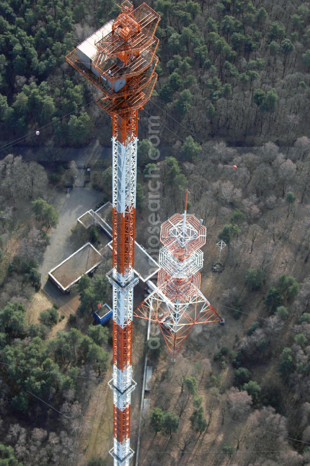 Aerial photograph Berlin-Frohnau - Blick auf die Richtfunkanlage Berlin-Frohnau. Die Richtfunkanlage Berlin-Frohnau befindet sich im Norden Berlins im Ortsteil Frohnau. Betreiber und Eigentümer der Richtfunkanlage ist die Deutsche Funkturm (DFMG), ein Tochterunternehmen der Deutschen Telekom mit Sitz in Münster. In Berlin-Frohnau steht das zweithöchste Bauwerk Berlins und eines der höchsten Bauwerke Deutschlands: Der von 1977 bis 1979 für 11,5 Mio. DM errichtete Richtfunkmast ist 358,58 m hoch und ermöglichte bis zur deutschen Wiedervereinigung eine Richtfunkverbindung mit der alten Bundesrepublik Deutschland. Der Sendemast verfügt nahe seiner Spitze über einen 4 m mal 5 m großen Betriebsraum für die Richtfunkgeräte. Er stellt den am höchsten über dem Erdboden liegenden geschlossenen Raum aller Bauwerke im EU-Gebiet dar. Kontakt: DFMG Deutsche Funkturm GmbH, 48008 Münster, Tel.: 0228181–4949,