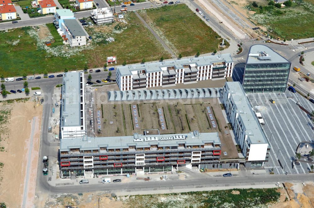 FRANKFURT / Main from the bird's eye view: Blick auf das Riedberg-Zentrum im neu entstehenden Stadtbezirk Riedberg von Frankfurt am Main in Hessen. Im Nordwesten der Mainmetropole wächst der neue Stadtteil mit Ein- und Mehrfamilienhäusern, Wohnungen, Geschäften, Parks, Restaurants, Büros, Kindereinrichtungen, Schulen, Arztpraxen, Hotels und Dienstleistungsbetrieben. Bis zum Jahr 2017 soll die Großsiedlung ca. 6000 Wohneinheiten mit rund 15.000 Einwohnern haben. Das Riedberg-Zentrum wurde Ende 2008 eröffnet und ist das Zentrum der wirtschaftlichen Versorgung Riedbergs. Im Erdgeschoss ist eine Ladengalerie mit diversen Einkaufsmöglichkeiten entstanden, darüber befinden sich 120 moderne Wohnungen. Der sechsgeschossige Solitär (rechts im Bild) ist ein Ärzte- und Bürohaus. Kontakt: RiedbergZentrum GmbH & Co. KG, Breitlacherstr. 94, 60489 Frankfurt am Main, Tel. +49 (0) 69 780 788 07