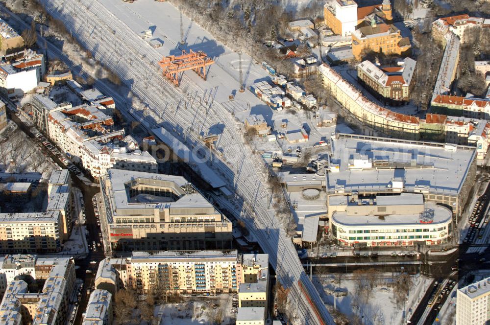 Berlin from the bird's eye view: Blick auf das winterlich, verschneite Ring Center 1 und 2 der ECE an der Frankfurter Alle am S-Bahnhof Frankfurter Alle. Im Hintergrund der schneebedeckte Containerbahnhof.