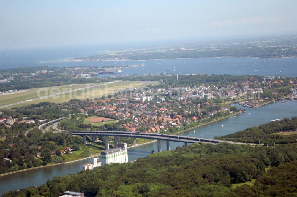 Aerial photograph Kiel - Blick auf die Uferseiten des Nord-Ostsee-Kanal und die Brücke Prinz-Heinrich-Straße in Kiel in Schleswig-Holstein / SH. Im Hintergrund ein Wohngebiet, der Flughafen Kiel-Holtenau und die Kieler Förde. View to the riverside of the Kiel Canal and the bridge Prinz-Heinrich-Straße in Kiel in Schleswig-Holstein / SH. In the background a residential area, the Airport Kiel and the Fjord Kiel.