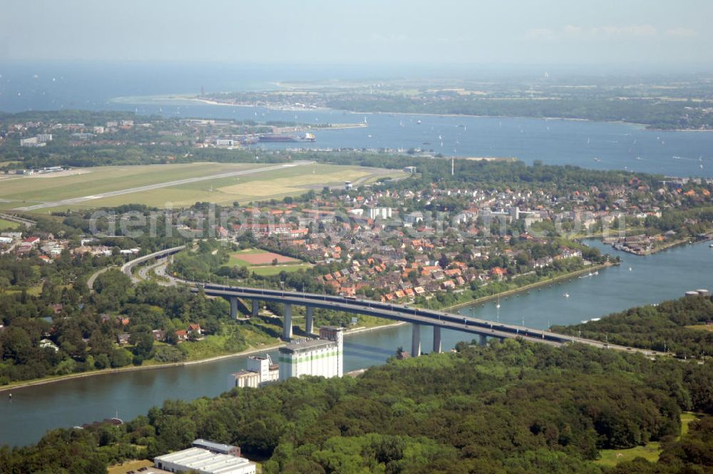 Kiel from above - Blick auf die Uferseiten des Nord-Ostsee-Kanal und die Brücke Prinz-Heinrich-Straße in Kiel in Schleswig-Holstein / SH. Im Hintergrund ein Wohngebiet, der Flughafen Kiel-Holtenau und die Kieler Förde. View to the riverside of the Kiel Canal and the bridge Prinz-Heinrich-Straße in Kiel in Schleswig-Holstein / SH. In the background a residential area, the Airport Kiel and the Fjord Kiel.