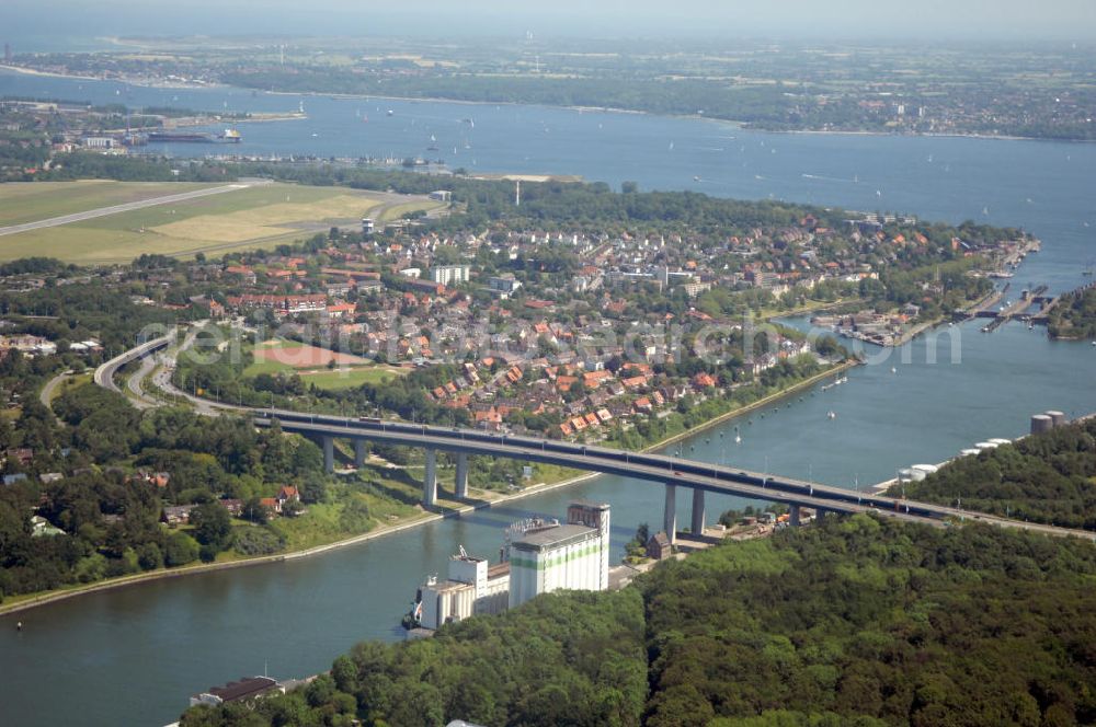 Kiel from the bird's eye view: Blick auf die Uferseiten des Nord-Ostsee-Kanal und die Brücke Prinz-Heinrich-Straße in Kiel in Schleswig-Holstein / SH. Im Hintergrund ein Wohngebiet, der Flughafen Kiel-Holtenau und die Kieler Förde. View to the riverside of the Kiel Canal and the bridge Prinz-Heinrich-Straße in Kiel in Schleswig-Holstein / SH. In the background a residential area, the Airport Kiel and the Fjord Kiel.