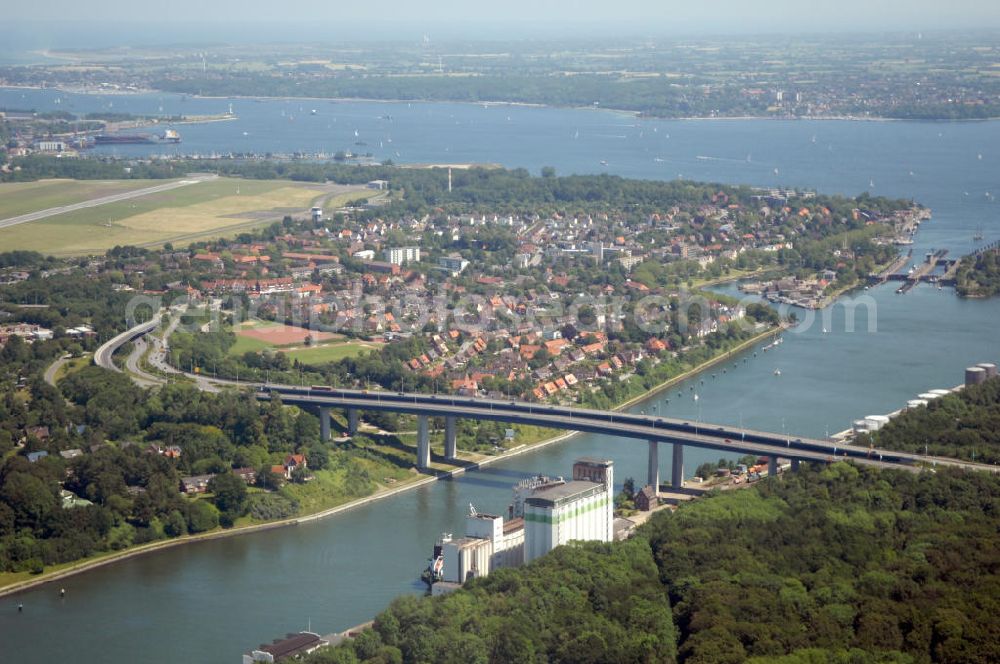 Aerial image Kiel - Blick auf die Uferseiten des Nord-Ostsee-Kanal und die Brücke Prinz-Heinrich-Straße in Kiel in Schleswig-Holstein / SH. Im Hintergrund ein Wohngebiet, der Flughafen Kiel-Holtenau und die Kieler Förde. View to the riverside of the Kiel Canal and the bridge Prinz-Heinrich-Straße in Kiel in Schleswig-Holstein / SH. In the background a residential area, the Airport Kiel and the Fjord Kiel.