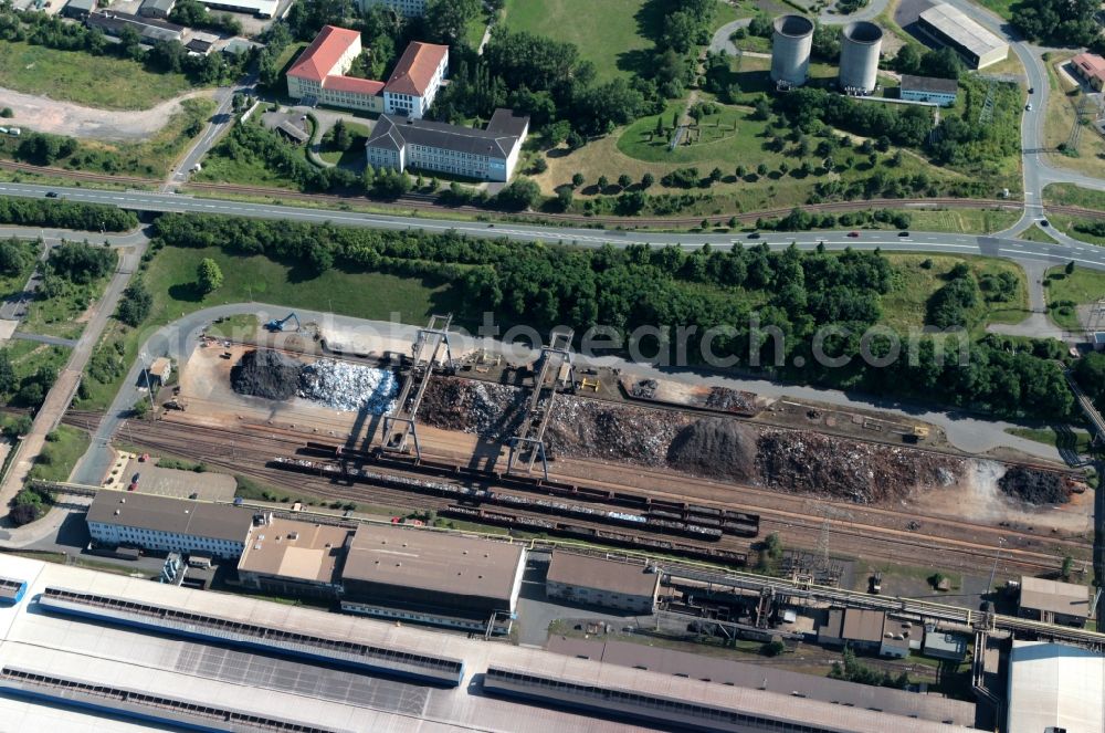 Aerial photograph Unterwellenborn - Go to site of the steel plant in Thuringia Unterwellenborn in Thuringia owns the stock of raw materials. Here, various raw materials are stored for the production process varietal purity. With a crane system, the recycling materials are transported. In the eye-catching buildings on the adjacent site, the education center Saalfeld GmbH and the State Vocational School Saalfeld are housed