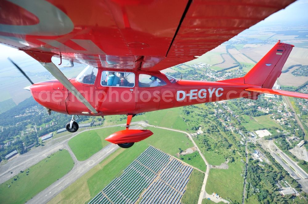 Aerial image Werneuchen - Bright red Cessna 172 D-EGYC of the agency euroluftbild.de in flight over the airfield in Werneuchen in the state Brandenburg, Germany