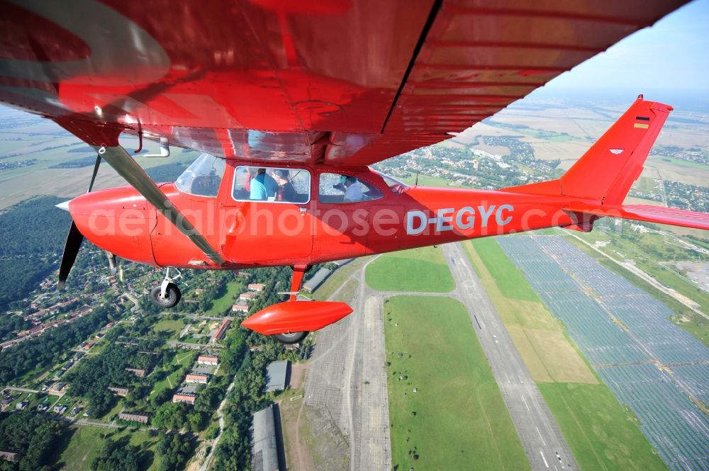 Werneuchen from above - Bright red Cessna 172 D-EGYC of the agency euroluftbild.de in flight over the airfield in Werneuchen in the state Brandenburg, Germany