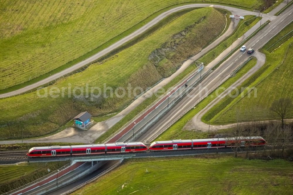 Hamm from the bird's eye view: Red regional train crosses a road underpass at Bockum-Hovel in Hamm in North Rhine-Westphalia