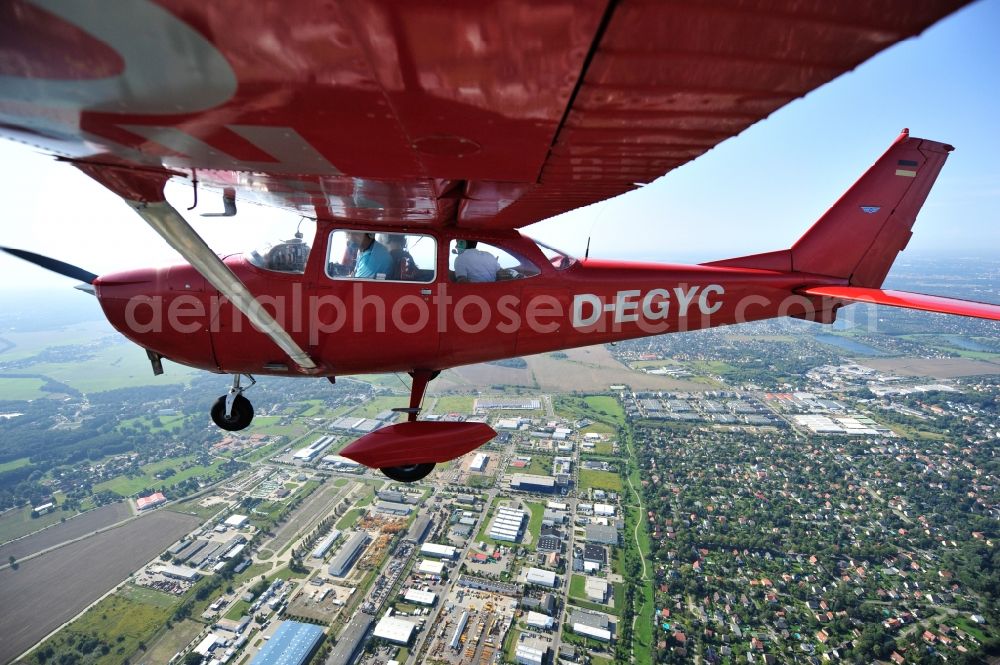 Hoppegarten from the bird's eye view: Red Cessna F172H with sign D-EGYC Aircraft in flight over the airspace in the district Dahlwitz-Hoppegarten in Hoppegarten in the state Brandenburg, Germany