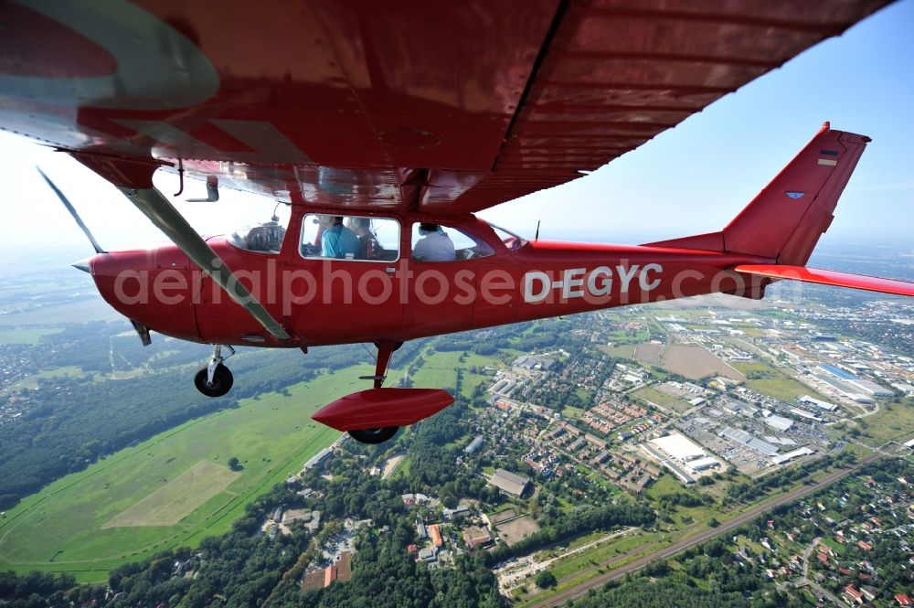 Aerial photograph Hoppegarten - Red Cessna F172H with sign D-EGYC Aircraft in flight over the airspace in the district Dahlwitz-Hoppegarten in Hoppegarten in the state Brandenburg, Germany