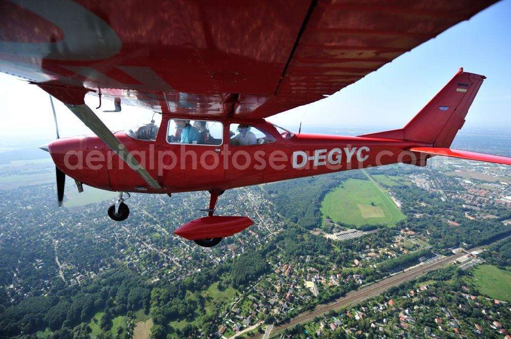 Hoppegarten from the bird's eye view: Red Cessna F172H with sign D-EGYC Aircraft in flight over the airspace in the district Dahlwitz-Hoppegarten in Hoppegarten in the state Brandenburg, Germany