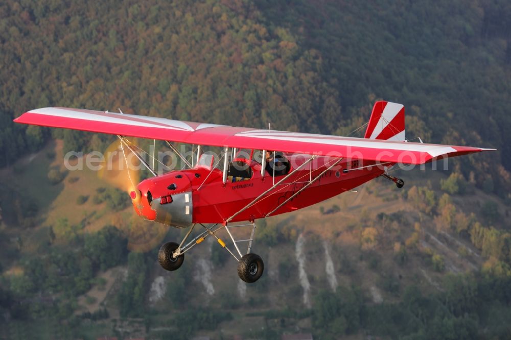 Bad Ditzenbach from the bird's eye view: Ultralight aircraft in flight above the sky Aircamper in roter Farbe mit der Kennung F-JRRL in Bad Ditzenbach in the state Baden-Wuerttemberg