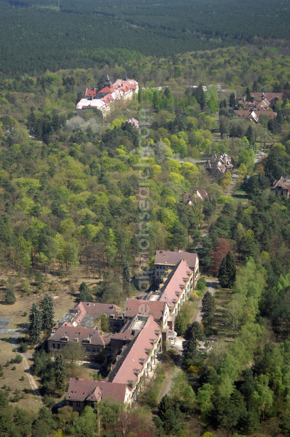 Aerial image Beelitz - Blick auf die Ruine des Chirurgie-Pavillon auf dem Gebiet der Lungenheilstätte für Frauen. Das Gebäude ist Teil der Heilstätten im Beelitzer Stadtwald und wurde im dritten Bauabschnitt von 1929 bis 1930 erbaut. Heute steht das Gebäude leer. Im 2. Weltkrieg dienten die Heilstätten, wie auch im 1. Weltkrieg, dem Militär als Lazarett. Zwischen 1945 und 1994 diente es den sowjetischen Truppen als zentrales Militärhospital der Westgruppe. Nach der Rückübertragung an die Landesversicherungsanstalt Berlin und den Verkauf durch diese an eine neu gebildete Eigentümergesellschaft, konnten mehrere Gebäude saniert und bis heute genutzt werden. Doch der grösste Teil der Gebäude verfällt seit der Insolvenz der Eigentümergesellschaft im Jahr 2000.