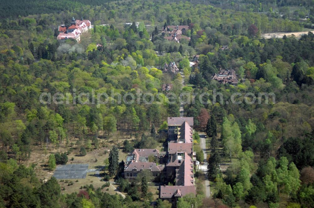 Aerial photograph Beelitz - Blick auf die Ruine des Chirurgie-Pavillon auf dem Gebiet der Lungenheilstätte für Frauen. Das Gebäude ist Teil der Heilstätten im Beelitzer Stadtwald und wurde im dritten Bauabschnitt von 1929 bis 1930 erbaut. Heute steht das Gebäude leer. Im 2. Weltkrieg dienten die Heilstätten, wie auch im 1. Weltkrieg, dem Militär als Lazarett. Zwischen 1945 und 1994 diente es den sowjetischen Truppen als zentrales Militärhospital der Westgruppe. Nach der Rückübertragung an die Landesversicherungsanstalt Berlin und den Verkauf durch diese an eine neu gebildete Eigentümergesellschaft, konnten mehrere Gebäude saniert und bis heute genutzt werden. Doch der grösste Teil der Gebäude verfällt seit der Insolvenz der Eigentümergesellschaft im Jahr 2000.