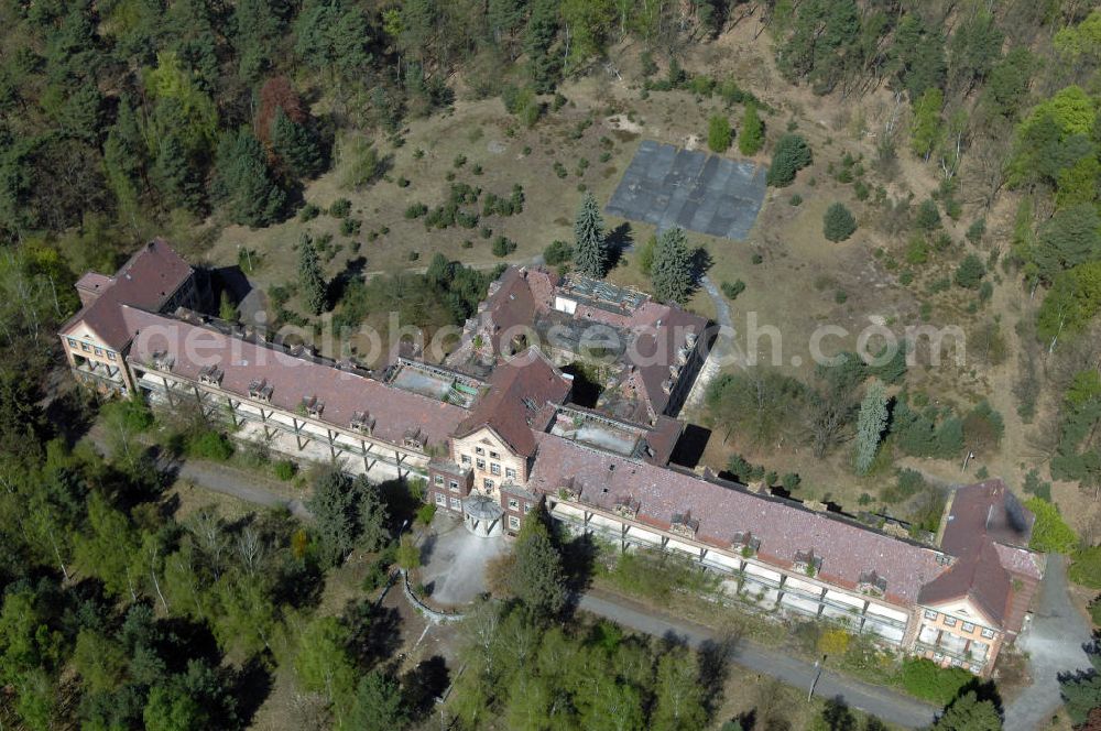 Aerial image Beelitz - Blick auf die Ruine des Chirurgie-Pavillon auf dem Gebiet der Lungenheilstätte für Frauen. Das Gebäude ist Teil der Heilstätten im Beelitzer Stadtwald und wurde im dritten Bauabschnitt von 1929 bis 1930 erbaut. Heute steht das Gebäude leer. Im 2. Weltkrieg dienten die Heilstätten, wie auch im 1. Weltkrieg, dem Militär als Lazarett. Zwischen 1945 und 1994 diente es den sowjetischen Truppen als zentrales Militärhospital der Westgruppe. Nach der Rückübertragung an die Landesversicherungsanstalt Berlin und den Verkauf durch diese an eine neu gebildete Eigentümergesellschaft, konnten mehrere Gebäude saniert und bis heute genutzt werden. Doch der grösste Teil der Gebäude verfällt seit der Insolvenz der Eigentümergesellschaft im Jahr 2000.