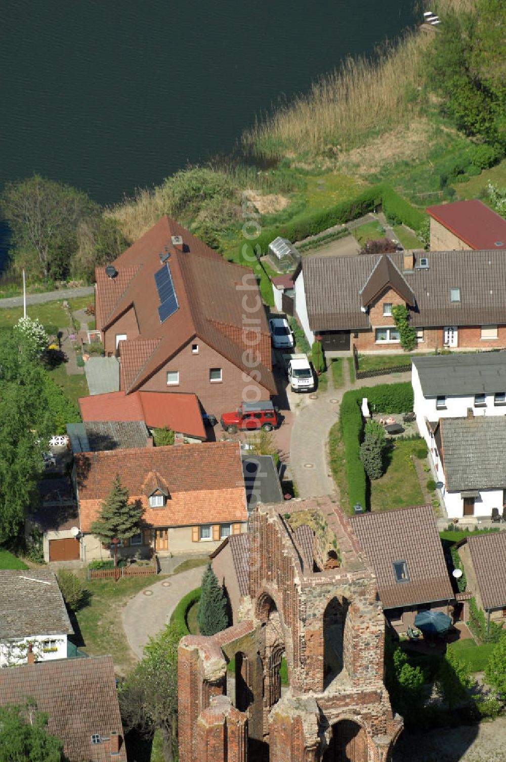 GRAMZOW from above - Blick auf Gramzow mit der Ruine der ehemaligen Klosterkirche. Erstmals wird Gramzow als Gramzowe im Jahr 1168 urkundlich erwähnt und ist somit ältester urkundlich überlieferter Ort der Uckermark. Im Jahr 1178 (ca.) wurde das Prämonstratenkloster gegründet. 1714 brannte die Klosterkirche nieder. Bis heute ist nur noch ein Teil der Westwand erhalten geblieben. Die Klosterruine ist ein Wahrzeichen Gramzows.