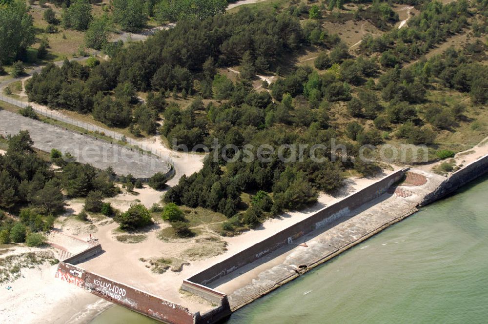 Aerial image Prora - Blick auf die nie fertig gestellte Seebrücke vom Seebad Prora. Der „Koloss von Prora“ bzw. KdF-Seebad Prora ist eine 18m-Modellanlage. Am 2. Mai 1936 fand die Grundsteinlegung des 1. von insgesamt 5 an der Nord und Ostseeküste geplanten Seebäder der 20.000 in Pora auf Rügen statt. Im November 1936 begannen 9 Baukonzerne und 48 Baufirmen mit ca. 5000 Arbeiter die Bauausführung, im Oktober 1938 konnte bereits Richtfest für das erste 500 m lange Unterkunftshaus gefeiert werden. Mit Kriegsbeginn 1939 wurden die Arbeiten auf der riesigen Großbaustelle stillgelegt. Nach 1945 wurden Teile des rohbauferigen KdF / Kraft durch Freude - Seebades demontiert und Abschnitte des Nordflügels von sowjetischen Truppen gesprengt. In den 50er Jahren übernahm die NVA der DDR das riesige Areal und baute es zu einem Militärstandort aus, etwa 10000 Soldaten und Offiziere waren ständig bis zur Auflösung 1990 in Prora kaserniert. Heute sind in dem historischen Gebäudekomplex u.a. folgende Einrichtungen untergebracht: Dokumentationszentrum der Stiftung NEUE KULTUR, das Museum zum Anfassen, KulturKunststatt Prora und die Grafik-Galerie.