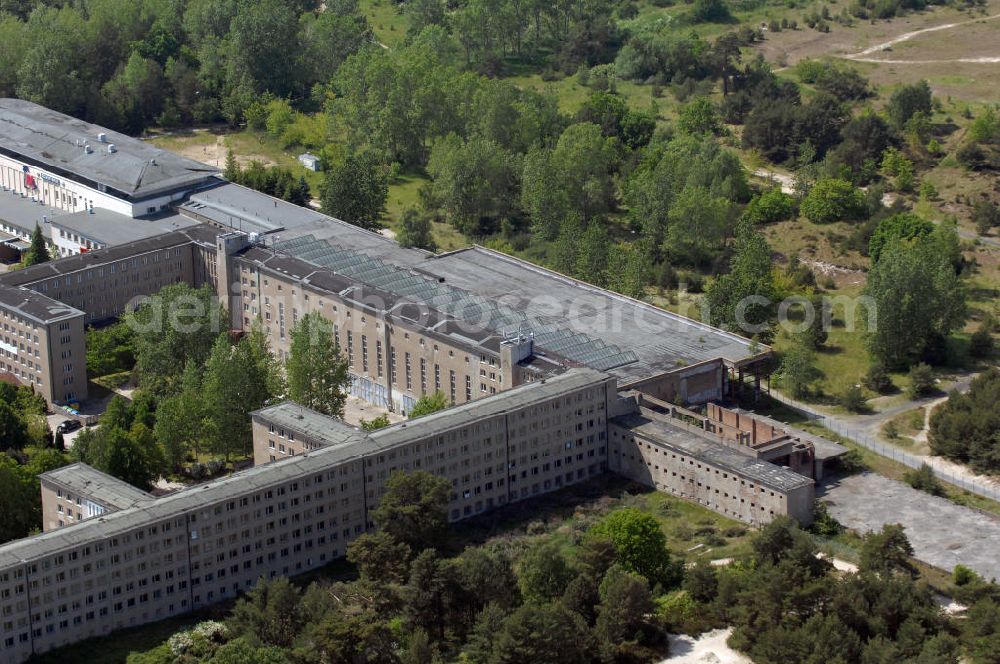 Aerial photograph Prora - Blick auf die heute ausgebaute Empfangshalle vom Seebad Prora. Der „Koloss von Prora“ bzw. KdF-Seebad Prora ist eine 18m-Modellanlage. Am 2. Mai 1936 fand die Grundsteinlegung des 1. von insgesamt 5 an der Nord und Ostseeküste geplanten Seebäder der 20.000 in Pora auf Rügen statt. Im November 1936 begannen 9 Baukonzerne und 48 Baufirmen mit ca. 5000 Arbeiter die Bauausführung, im Oktober 1938 konnte bereits Richtfest für das erste 500 m lange Unterkunftshaus gefeiert werden. Mit Kriegsbeginn 1939 wurden die Arbeiten auf der riesigen Großbaustelle stillgelegt. Nach 1945 wurden Teile des rohbauferigen KdF / Kraft durch Freude - Seebades demontiert und Abschnitte des Nordflügels von sowjetischen Truppen gesprengt. In den 50er Jahren übernahm die NVA der DDR das riesige Areal und baute es zu einem Militärstandort aus, etwa 10000 Soldaten und Offiziere waren ständig bis zur Auflösung 1990 in Prora kaserniert. Heute sind in dem historischen Gebäudekomplex u.a. folgende Einrichtungen untergebracht: Dokumentationszentrum der Stiftung NEUE KULTUR, das Museum zum Anfassen, KulturKunststatt Prora und die Grafik-Galerie.