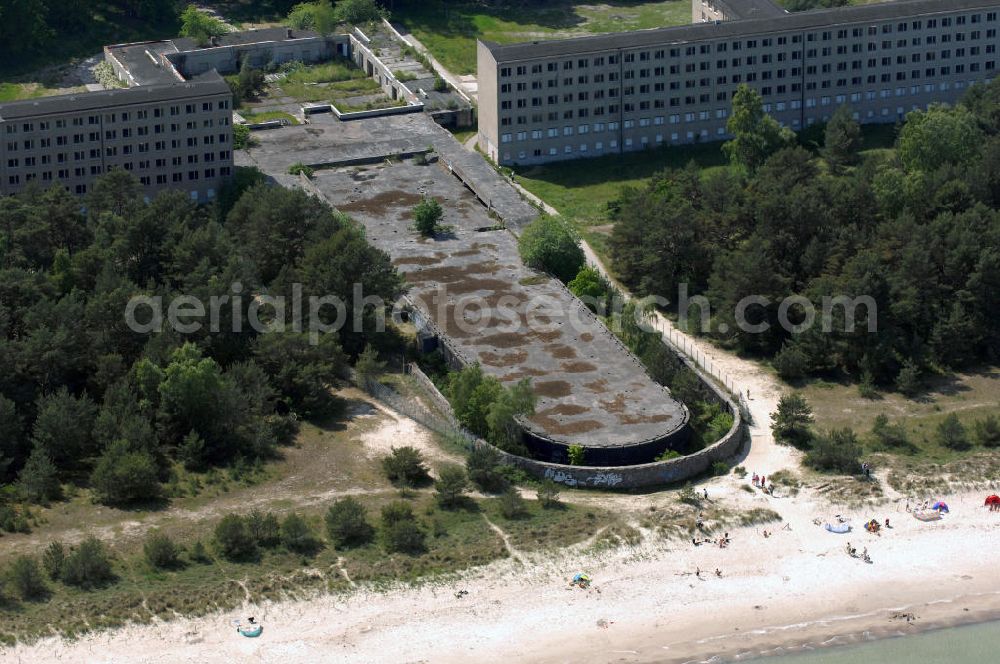 Prora from above - Blick auf den nie fertig gestellten Gebäudeteil mit Gemeinschaftsräumen im Nordflügel 1 vom Seebad Prora. Der „Koloss von Prora“ bzw. KdF-Seebad Prora ist eine 18m-Modellanlage. Am 2. Mai 1936 fand die Grundsteinlegung des 1. von insgesamt 5 an der Nord und Ostseeküste geplanten Seebäder der 20.000 in Pora auf Rügen statt. Im November 1936 begannen 9 Baukonzerne und 48 Baufirmen mit ca. 5000 Arbeiter die Bauausführung, im Oktober 1938 konnte bereits Richtfest für das erste 500 m lange Unterkunftshaus gefeiert werden. Mit Kriegsbeginn 1939 wurden die Arbeiten auf der riesigen Großbaustelle stillgelegt. Nach 1945 wurden Teile des rohbauferigen KdF / Kraft durch Freude - Seebades demontiert und Abschnitte des Nordflügels von sowjetischen Truppen gesprengt. In den 50er Jahren übernahm die NVA der DDR das riesige Areal und baute es zu einem Militärstandort aus, etwa 10000 Soldaten und Offiziere waren ständig bis zur Auflösung 1990 in Prora kaserniert. Heute sind in dem historischen Gebäudekomplex u.a. folgende Einrichtungen untergebracht: Dokumentationszentrum der Stiftung NEUE KULTUR, das Museum zum Anfassen, KulturKunststatt Prora und die Grafik-Galerie.