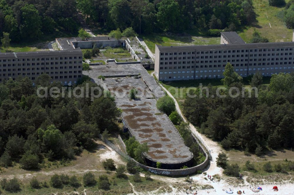 Prora from the bird's eye view: Blick auf den nie fertig gestellten Gebäudeteil mit Gemeinschaftsräumen im Nordflügel 1 vom Seebad Prora. Der „Koloss von Prora“ bzw. KdF-Seebad Prora ist eine 18m-Modellanlage. Am 2. Mai 1936 fand die Grundsteinlegung des 1. von insgesamt 5 an der Nord und Ostseeküste geplanten Seebäder der 20.000 in Pora auf Rügen statt. Im November 1936 begannen 9 Baukonzerne und 48 Baufirmen mit ca. 5000 Arbeiter die Bauausführung, im Oktober 1938 konnte bereits Richtfest für das erste 500 m lange Unterkunftshaus gefeiert werden. Mit Kriegsbeginn 1939 wurden die Arbeiten auf der riesigen Großbaustelle stillgelegt. Nach 1945 wurden Teile des rohbauferigen KdF / Kraft durch Freude - Seebades demontiert und Abschnitte des Nordflügels von sowjetischen Truppen gesprengt. In den 50er Jahren übernahm die NVA der DDR das riesige Areal und baute es zu einem Militärstandort aus, etwa 10000 Soldaten und Offiziere waren ständig bis zur Auflösung 1990 in Prora kaserniert. Heute sind in dem historischen Gebäudekomplex u.a. folgende Einrichtungen untergebracht: Dokumentationszentrum der Stiftung NEUE KULTUR, das Museum zum Anfassen, KulturKunststatt Prora und die Grafik-Galerie.