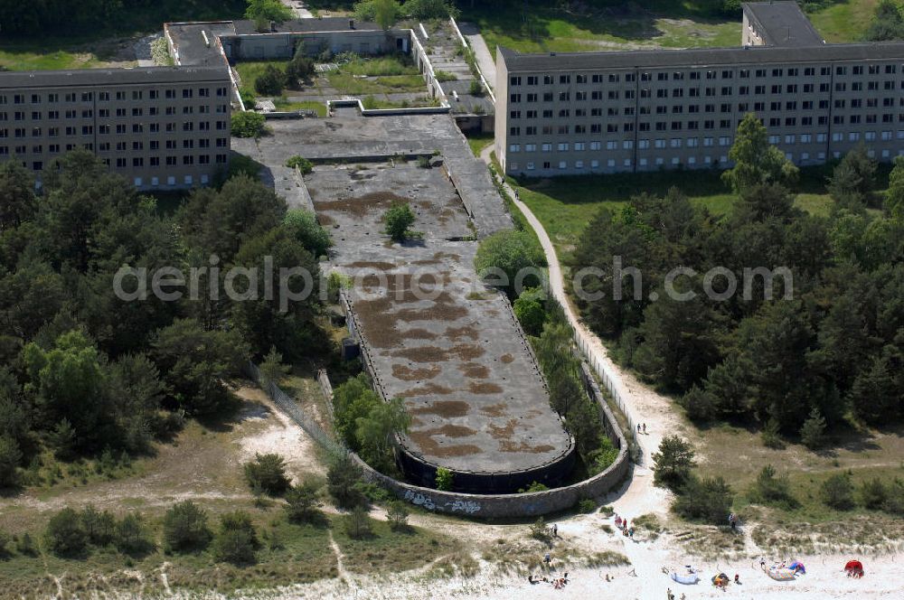 Aerial image Prora - Blick auf den nie fertig gestellten Gebäudeteil mit Gemeinschaftsräumen im Nordflügel 1 vom Seebad Prora. Der „Koloss von Prora“ bzw. KdF-Seebad Prora ist eine 18m-Modellanlage. Am 2. Mai 1936 fand die Grundsteinlegung des 1. von insgesamt 5 an der Nord und Ostseeküste geplanten Seebäder der 20.000 in Pora auf Rügen statt. Im November 1936 begannen 9 Baukonzerne und 48 Baufirmen mit ca. 5000 Arbeiter die Bauausführung, im Oktober 1938 konnte bereits Richtfest für das erste 500 m lange Unterkunftshaus gefeiert werden. Mit Kriegsbeginn 1939 wurden die Arbeiten auf der riesigen Großbaustelle stillgelegt. Nach 1945 wurden Teile des rohbauferigen KdF / Kraft durch Freude - Seebades demontiert und Abschnitte des Nordflügels von sowjetischen Truppen gesprengt. In den 50er Jahren übernahm die NVA der DDR das riesige Areal und baute es zu einem Militärstandort aus, etwa 10000 Soldaten und Offiziere waren ständig bis zur Auflösung 1990 in Prora kaserniert. Heute sind in dem historischen Gebäudekomplex u.a. folgende Einrichtungen untergebracht: Dokumentationszentrum der Stiftung NEUE KULTUR, das Museum zum Anfassen, KulturKunststatt Prora und die Grafik-Galerie.