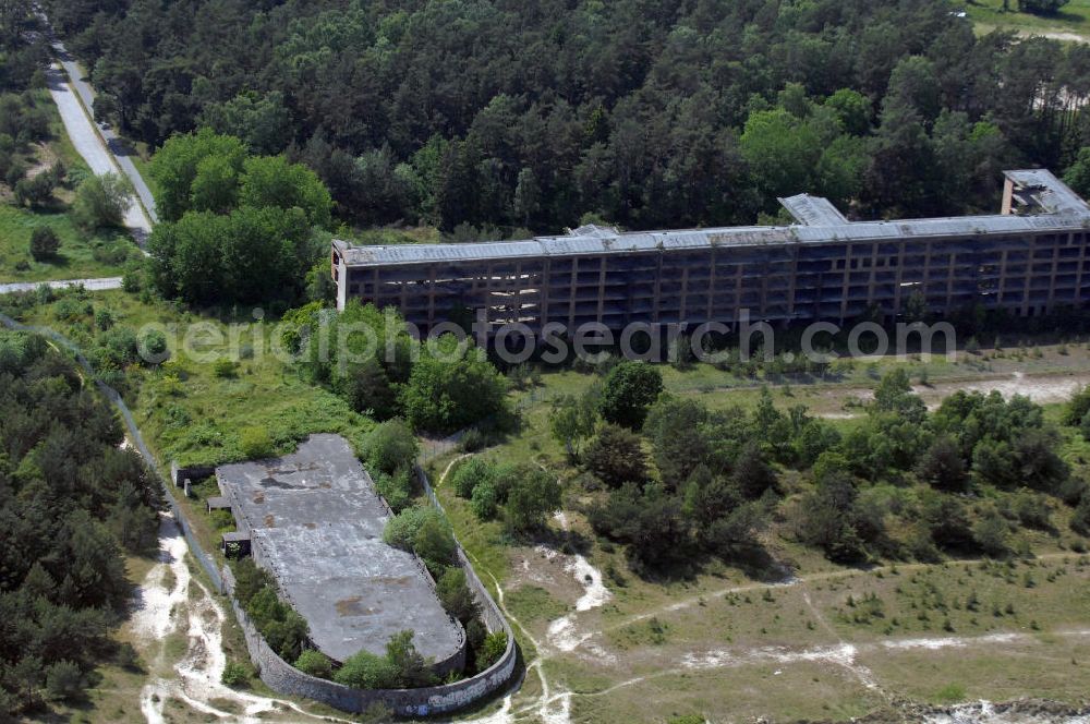 Prora from above - Blick auf den nie fertig gestellten Gebäudeteil mit Gemeinschaftsräumen im Nordflügel 3 vom Seebad Prora. Der „Koloss von Prora“ bzw. KdF-Seebad Prora ist eine 18m-Modellanlage. Am 2. Mai 1936 fand die Grundsteinlegung des 1. von insgesamt 5 an der Nord und Ostseeküste geplanten Seebäder der 20.000 in Pora auf Rügen statt. Im November 1936 begannen 9 Baukonzerne und 48 Baufirmen mit ca. 5000 Arbeiter die Bauausführung, im Oktober 1938 konnte bereits Richtfest für das erste 500 m lange Unterkunftshaus gefeiert werden. Mit Kriegsbeginn 1939 wurden die Arbeiten auf der riesigen Großbaustelle stillgelegt. Nach 1945 wurden Teile des rohbauferigen KdF / Kraft durch Freude - Seebades demontiert und Abschnitte des Nordflügels von sowjetischen Truppen gesprengt. In den 50er Jahren übernahm die NVA der DDR das riesige Areal und baute es zu einem Militärstandort aus, etwa 10000 Soldaten und Offiziere waren ständig bis zur Auflösung 1990 in Prora kaserniert. Heute sind in dem historischen Gebäudekomplex u.a. folgende Einrichtungen untergebracht: Dokumentationszentrum der Stiftung NEUE KULTUR, das Museum zum Anfassen, KulturKunststatt Prora und die Grafik-Galerie.