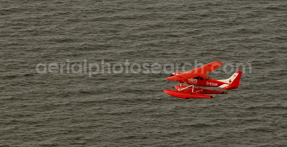 Aerial image Rostock - Scenic flight of a red seaplane seaplane Cessna 206 with the registration D-EGUF over the Baltic Sea on the coast of Rostock in Mecklenburg-Vorpommern