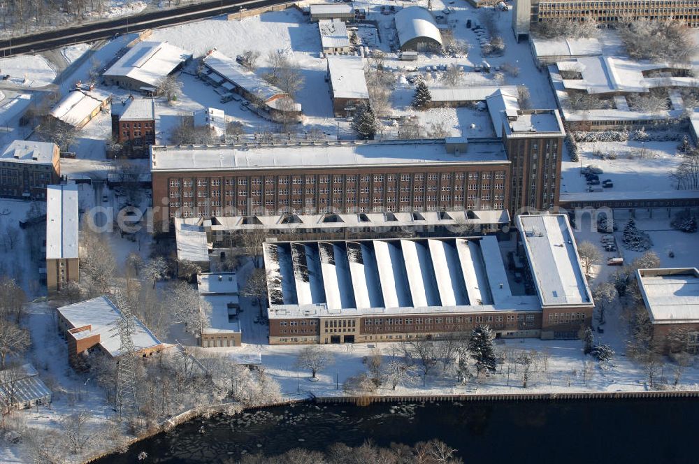 Aerial photograph Berlin - Blick auf das winterlich mit Schnee bedeckte Rundfunkzentrum Nalepastrasse. Es zählt zu den bedeutensten Funkbauten der DDR. Hier wurden Maßstäbe für die Rundfunkkultur gesetzt. Dieses mächtige Medium war sowohl Propagandamittel im Kampf der Systeme und Mittel zur Darstellung nach außen als auch nicht zu unterschätzender Kulturträger in der Gesellschaft der DDR. Es ist fast vollständig - bis auf die elektronische Einrichtung - im Zustand der Erbauungszeit erhalten. Man findet hier zum Beispiel Musikaufnahme- und Hörspielstudios. Wegen ihrer sehr guten akustischen Eigenschaften sind die Studios und die Aufnahmesäle für jede Art von Tonaufnahmen auch heute noch nutzbar. Zur Zeit steht das Gebäude leer.