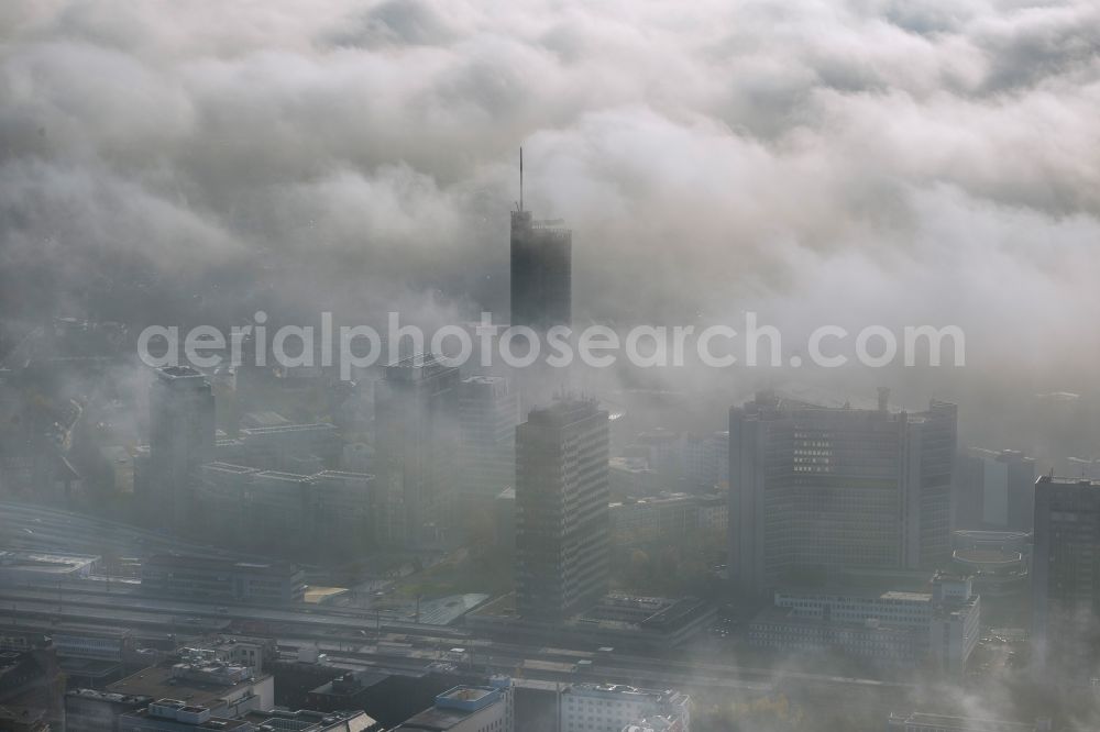 Essen from the bird's eye view: View of the RWE tower shrouded with fog and an impressive cloud bank over the city center of Essen in the state North Rhine-Westphalia. The autumn weather clouds are surrounding the skyscraper headquarters of energy supplier RWE at Opernplatz and form a thick cover over the Ruhr region city