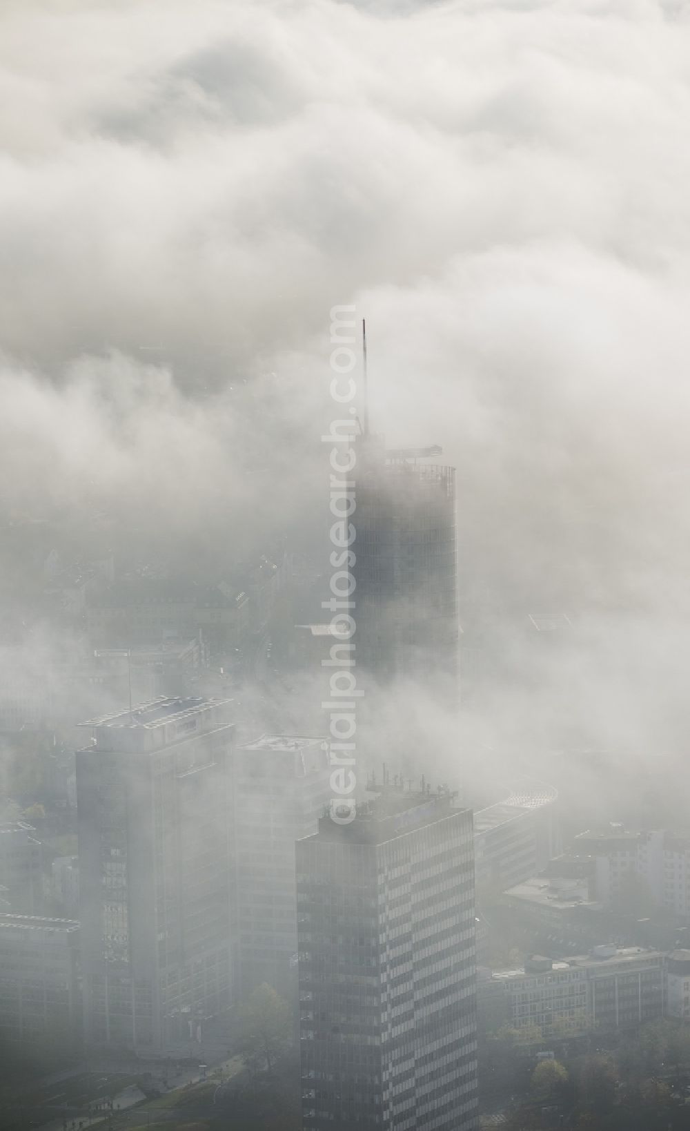 Aerial photograph Essen - View of the RWE tower shrouded with fog and an impressive cloud bank over the city center of Essen in the state North Rhine-Westphalia. The autumn weather clouds are surrounding the skyscraper headquarters of energy supplier RWE at Opernplatz and form a thick cover over the Ruhr region city