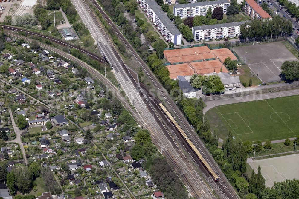 Berlin from the bird's eye view: Overground train on the railway tracks between sports facilities and allotements in the borough of Baumschulweg in Berlin in Berlin, Germany