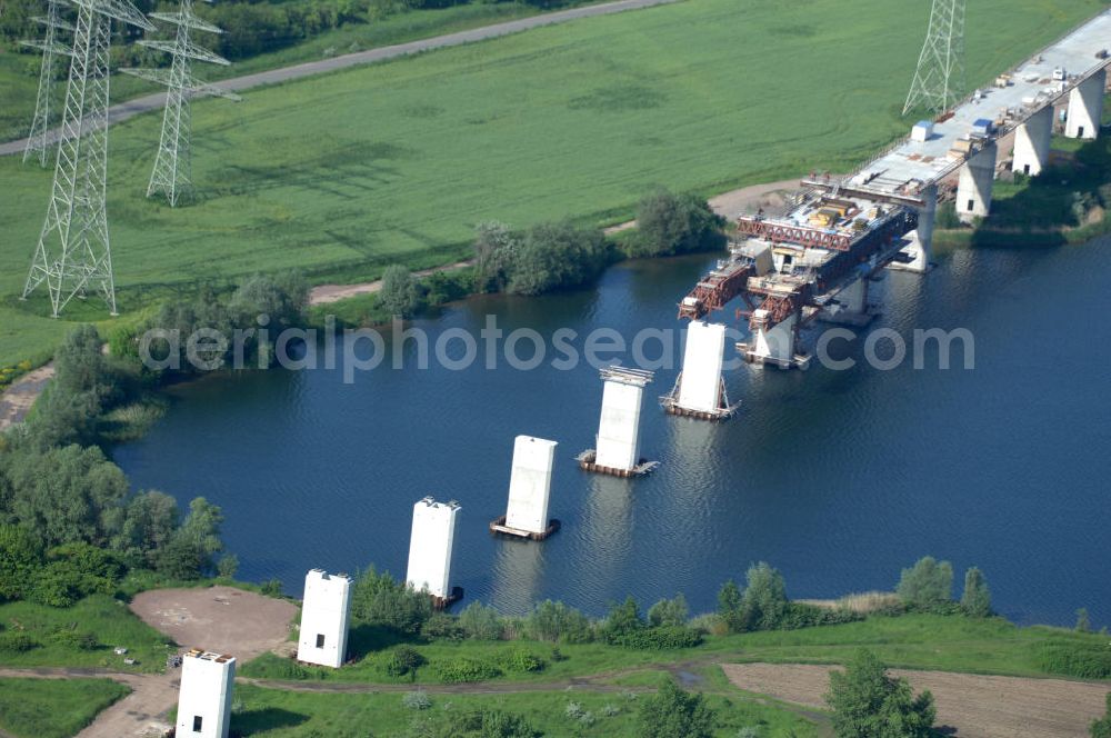 Aerial photograph Rattmannsdorf - Blick auf die Vorschub- Bauarbeiten an der Saale-Elster-Talbrücke über den Rattmannsdorfer See. Das Beton- Viadukt mit insgesamt 8, 5 Kilometern Länge wird teilweise mit großen Baugerüsten in so genannter Vor-Kopf-Bauweise errichtet, bei der zur Schonung der Umwelt alle Arbeitsschritte von der fertigten Brücke aus erfolgen und keine Baustraßen notwendig sind. Die ICE - Neubaustrecke im Projekt VDE 8 Nürnberg-Berlin der Deutschen Bahn soll 2015 in Betrieb gehen und wird das bisher längste Brückenbauwerk Deutschlands sein. Bauausführende Firmen sind die Hochtief Construction AG, Adam Hörnig, Gerdum und Breuer; Franki Grundbau; Doka Schalungstechniker; BBV Vorspanntechnik; Röro Traggerüstsysteme; Oevermann Hoch- und Tiefbau, Teupe & Söhne Gerüstbau GmbH, Alpine Bau und Arcelormittal. View of the construction of the Saale-Elster Viaduct on the Rattmannsdorfer lake.