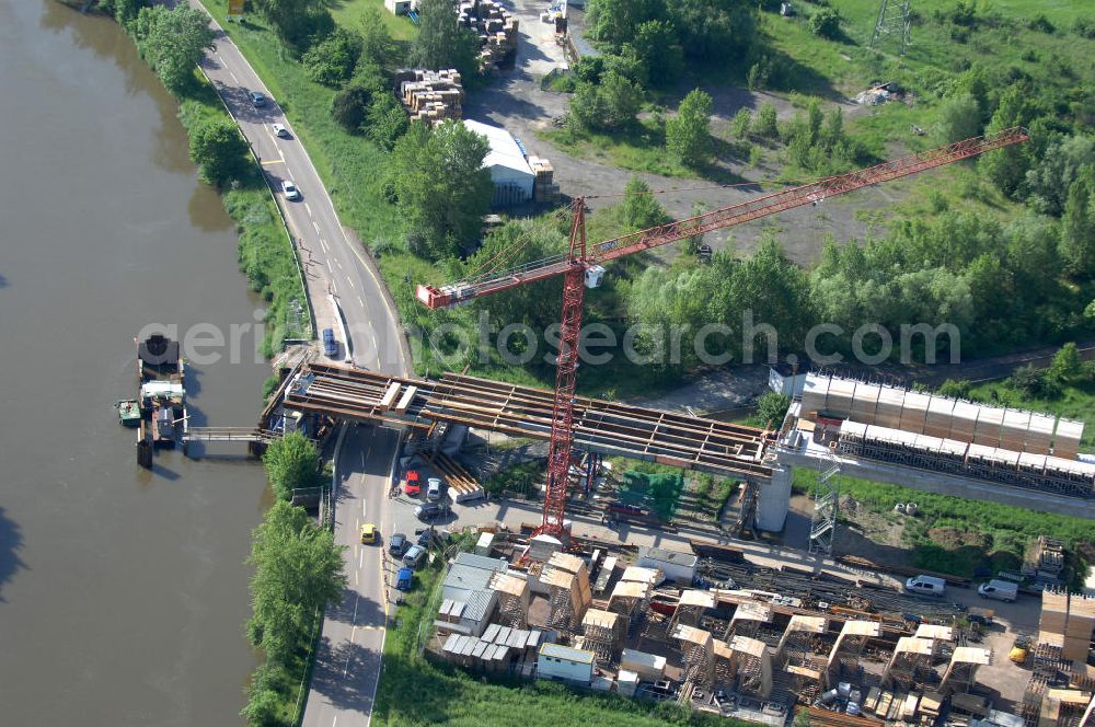 Aerial image Rattmannsdorf - Blick auf die Vorschub- Bauarbeiten an der Saale-Elster-Talbrücke über den Rattmannsdorfer See. Das Beton- Viadukt mit insgesamt 8, 5 Kilometern Länge wird teilweise mit großen Baugerüsten in so genannter Vor-Kopf-Bauweise errichtet, bei der zur Schonung der Umwelt alle Arbeitsschritte von der fertigten Brücke aus erfolgen und keine Baustraßen notwendig sind. Die ICE - Neubaustrecke im Projekt VDE 8 Nürnberg-Berlin der Deutschen Bahn soll 2015 in Betrieb gehen und wird das bisher längste Brückenbauwerk Deutschlands sein. Bauausführende Firmen sind die Hochtief Construction AG, Adam Hörnig, Gerdum und Breuer; Franki Grundbau; Doka Schalungstechniker; BBV Vorspanntechnik; Röro Traggerüstsysteme; Oevermann Hoch- und Tiefbau, Teupe & Söhne Gerüstbau GmbH, Alpine Bau und Arcelormittal. View of the construction of the Saale-Elster Viaduct on the Rattmannsdorfer lake.