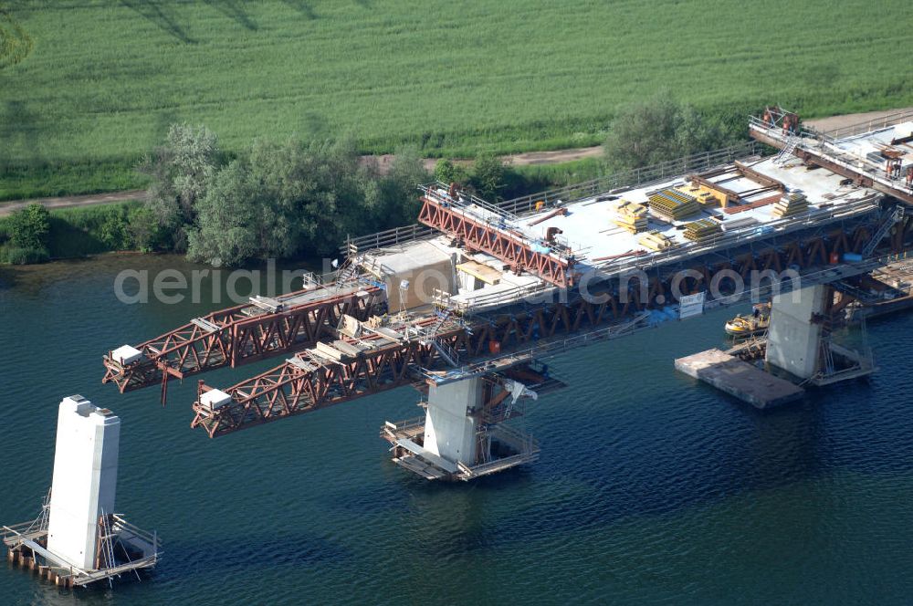 Aerial photograph Rattmannsdorf - Blick auf die Vorschub- Bauarbeiten an der Saale-Elster-Talbrücke über den Rattmannsdorfer See. Das Beton- Viadukt mit insgesamt 8, 5 Kilometern Länge wird teilweise mit großen Baugerüsten in so genannter Vor-Kopf-Bauweise errichtet, bei der zur Schonung der Umwelt alle Arbeitsschritte von der fertigten Brücke aus erfolgen und keine Baustraßen notwendig sind. Die ICE - Neubaustrecke im Projekt VDE 8 Nürnberg-Berlin der Deutschen Bahn soll 2015 in Betrieb gehen und wird das bisher längste Brückenbauwerk Deutschlands sein. Bauausführende Firmen sind die Hochtief Construction AG, Adam Hörnig, Gerdum und Breuer; Franki Grundbau; Doka Schalungstechniker; BBV Vorspanntechnik; Röro Traggerüstsysteme; Oevermann Hoch- und Tiefbau, Teupe & Söhne Gerüstbau GmbH, Alpine Bau und Arcelormittal. View of the construction of the Saale-Elster Viaduct on the Rattmannsdorfer lake.