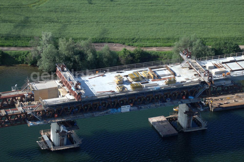 Rattmannsdorf from above - Blick auf die Vorschub- Bauarbeiten an der Saale-Elster-Talbrücke über den Rattmannsdorfer See. Das Beton- Viadukt mit insgesamt 8, 5 Kilometern Länge wird teilweise mit großen Baugerüsten in so genannter Vor-Kopf-Bauweise errichtet, bei der zur Schonung der Umwelt alle Arbeitsschritte von der fertigten Brücke aus erfolgen und keine Baustraßen notwendig sind. Die ICE - Neubaustrecke im Projekt VDE 8 Nürnberg-Berlin der Deutschen Bahn soll 2015 in Betrieb gehen und wird das bisher längste Brückenbauwerk Deutschlands sein. Bauausführende Firmen sind die Hochtief Construction AG, Adam Hörnig, Gerdum und Breuer; Franki Grundbau; Doka Schalungstechniker; BBV Vorspanntechnik; Röro Traggerüstsysteme; Oevermann Hoch- und Tiefbau, Teupe & Söhne Gerüstbau GmbH, Alpine Bau und Arcelormittal. View of the construction of the Saale-Elster Viaduct on the Rattmannsdorfer lake.