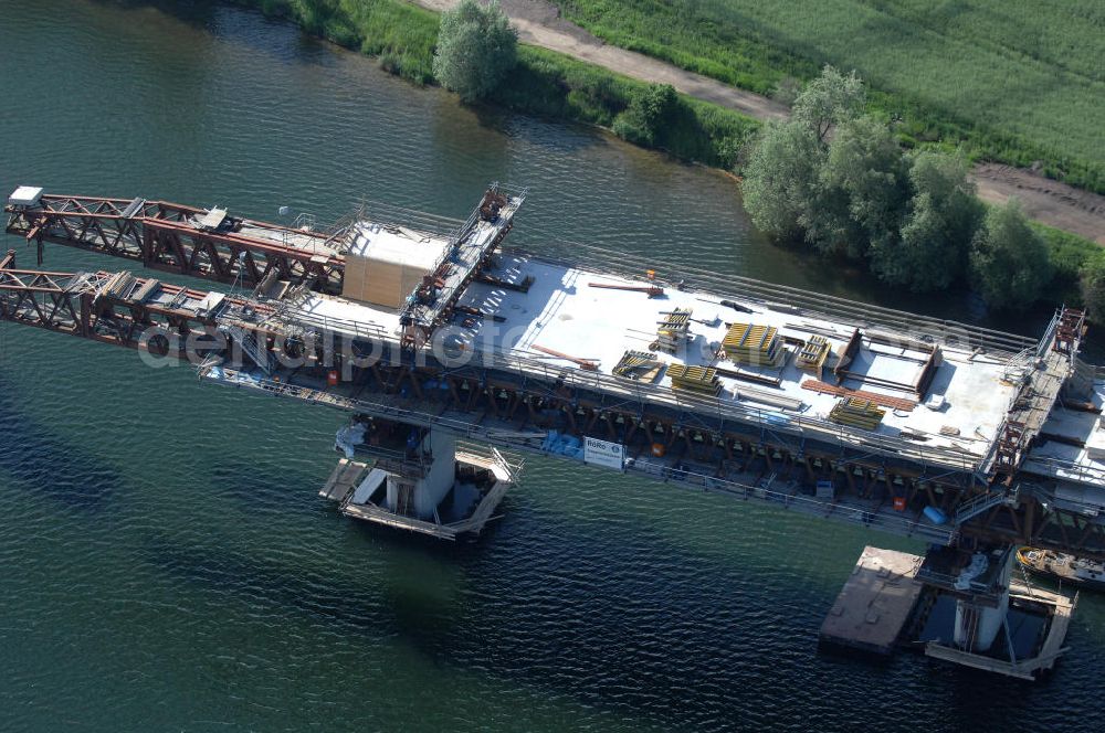 Aerial image Rattmannsdorf - Blick auf die Vorschub- Bauarbeiten an der Saale-Elster-Talbrücke über den Rattmannsdorfer See. Das Beton- Viadukt mit insgesamt 8, 5 Kilometern Länge wird teilweise mit großen Baugerüsten in so genannter Vor-Kopf-Bauweise errichtet, bei der zur Schonung der Umwelt alle Arbeitsschritte von der fertigten Brücke aus erfolgen und keine Baustraßen notwendig sind. Die ICE - Neubaustrecke im Projekt VDE 8 Nürnberg-Berlin der Deutschen Bahn soll 2015 in Betrieb gehen und wird das bisher längste Brückenbauwerk Deutschlands sein. Bauausführende Firmen sind die Hochtief Construction AG, Adam Hörnig, Gerdum und Breuer; Franki Grundbau; Doka Schalungstechniker; BBV Vorspanntechnik; Röro Traggerüstsysteme; Oevermann Hoch- und Tiefbau, Teupe & Söhne Gerüstbau GmbH, Alpine Bau und Arcelormittal. View of the construction of the Saale-Elster Viaduct on the Rattmannsdorfer lake.