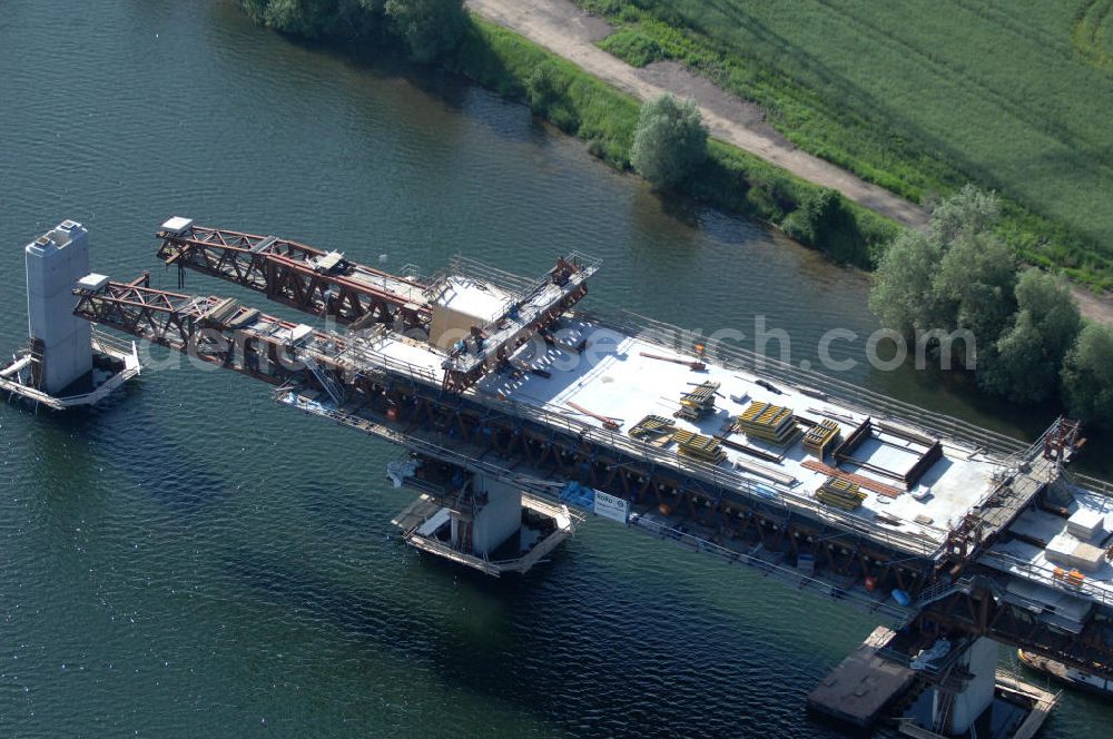 Aerial photograph Rattmannsdorf - Blick auf die Vorschub- Bauarbeiten an der Saale-Elster-Talbrücke über den Rattmannsdorfer See. Das Beton- Viadukt mit insgesamt 8, 5 Kilometern Länge wird teilweise mit großen Baugerüsten in so genannter Vor-Kopf-Bauweise errichtet, bei der zur Schonung der Umwelt alle Arbeitsschritte von der fertigten Brücke aus erfolgen und keine Baustraßen notwendig sind. Die ICE - Neubaustrecke im Projekt VDE 8 Nürnberg-Berlin der Deutschen Bahn soll 2015 in Betrieb gehen und wird das bisher längste Brückenbauwerk Deutschlands sein. Bauausführende Firmen sind die Hochtief Construction AG, Adam Hörnig, Gerdum und Breuer; Franki Grundbau; Doka Schalungstechniker; BBV Vorspanntechnik; Röro Traggerüstsysteme; Oevermann Hoch- und Tiefbau, Teupe & Söhne Gerüstbau GmbH, Alpine Bau und Arcelormittal. View of the construction of the Saale-Elster Viaduct on the Rattmannsdorfer lake.